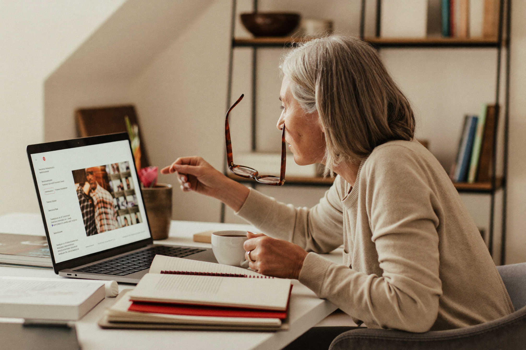 Woman in her fifties reviewing information on a laptop at her home desk