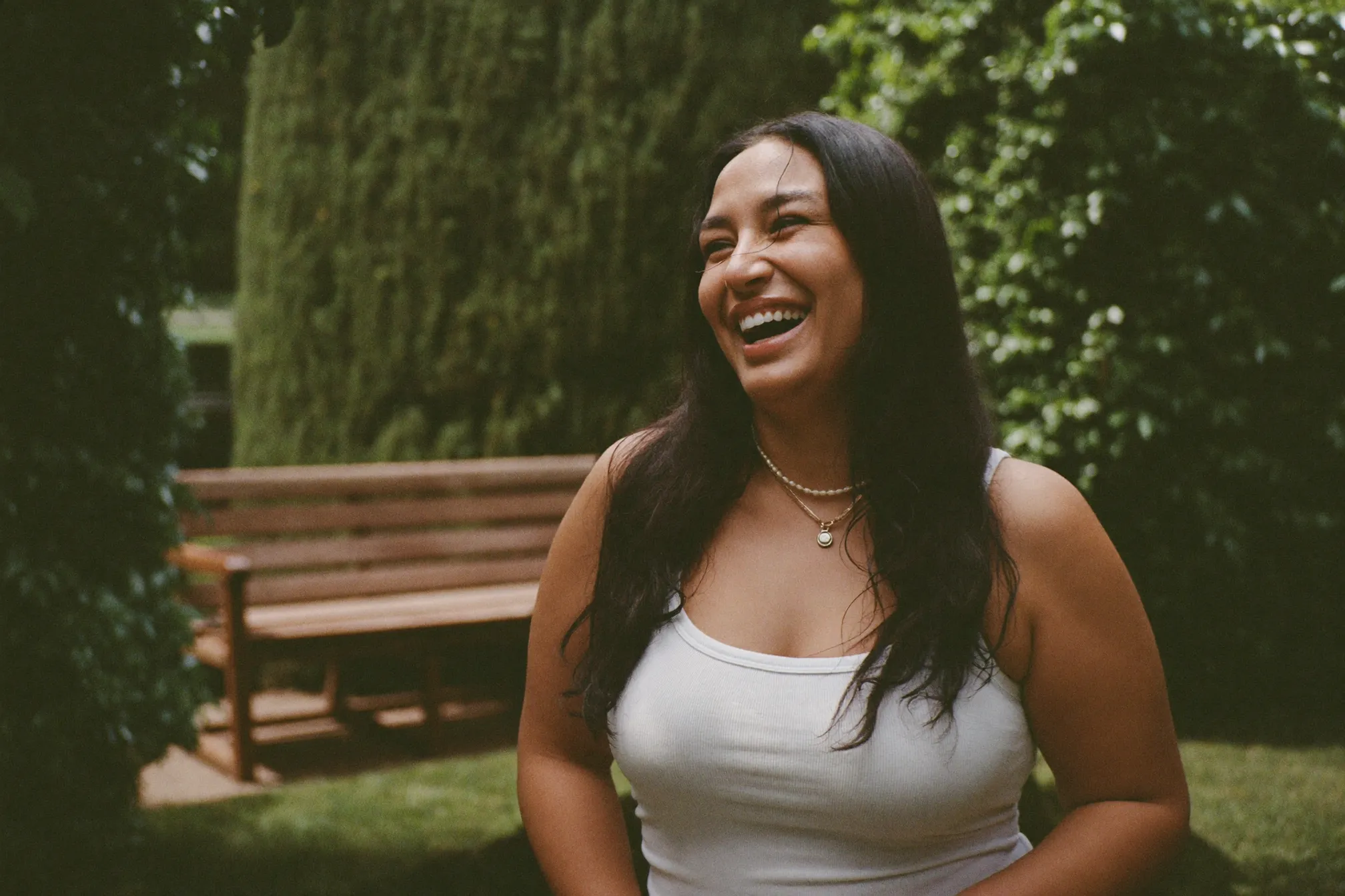 Smiling woman in her 50s outdoors, illustrating stress incontinence and bladder leaks when laughing or sneezing